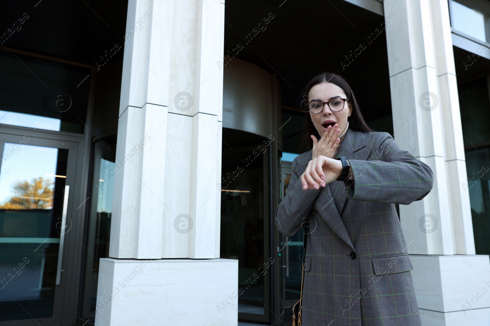 Photo of Emotional woman checking time on watch outdoors. Being late concept