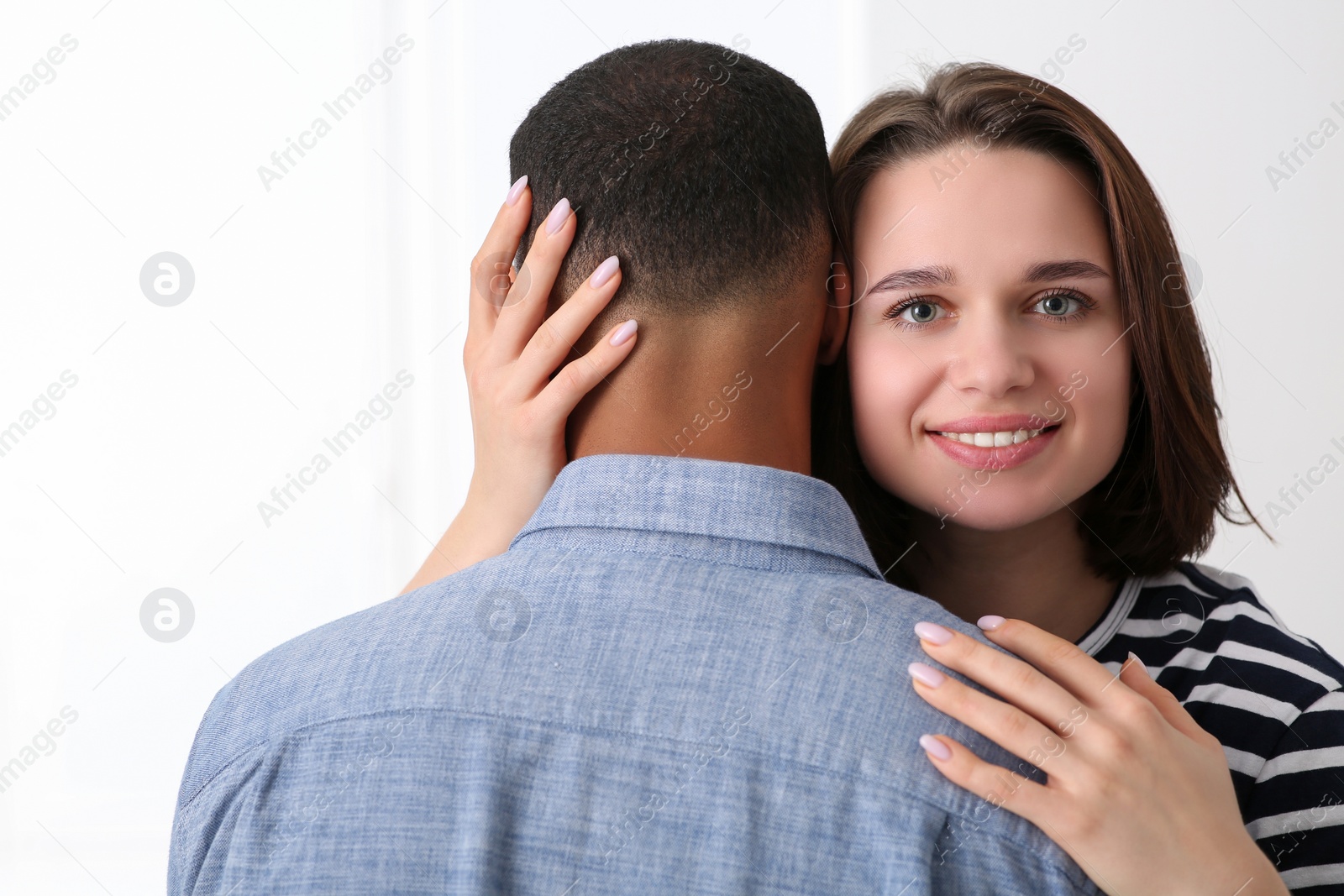 Photo of Dating agency. Woman hugging her boyfriend on white background