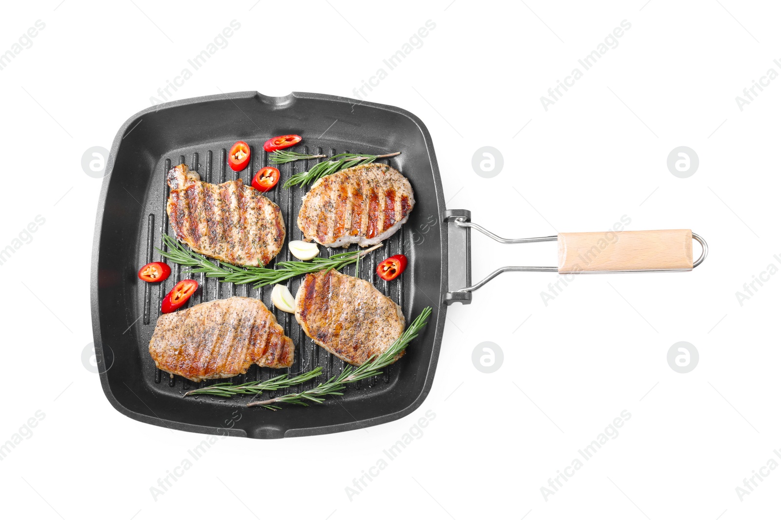 Photo of Grill pan with delicious pork steaks, garlic, chili pepper and rosemary isolated on white, top view