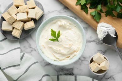 Photo of Delicious tofu cheese with parsley and spoon on white marble table, flat lay