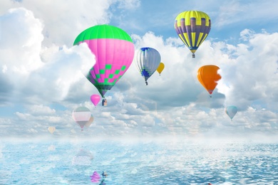 Image of Fantastic dreams. Hot air balloons in sky with fluffy clouds over sea
