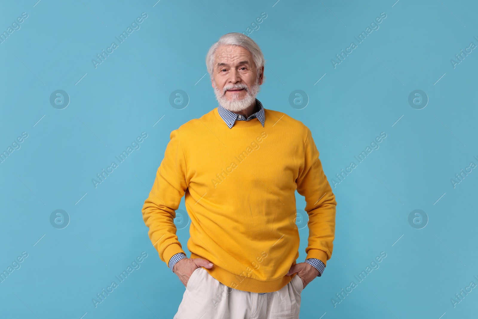 Photo of Portrait of stylish grandpa on light blue background