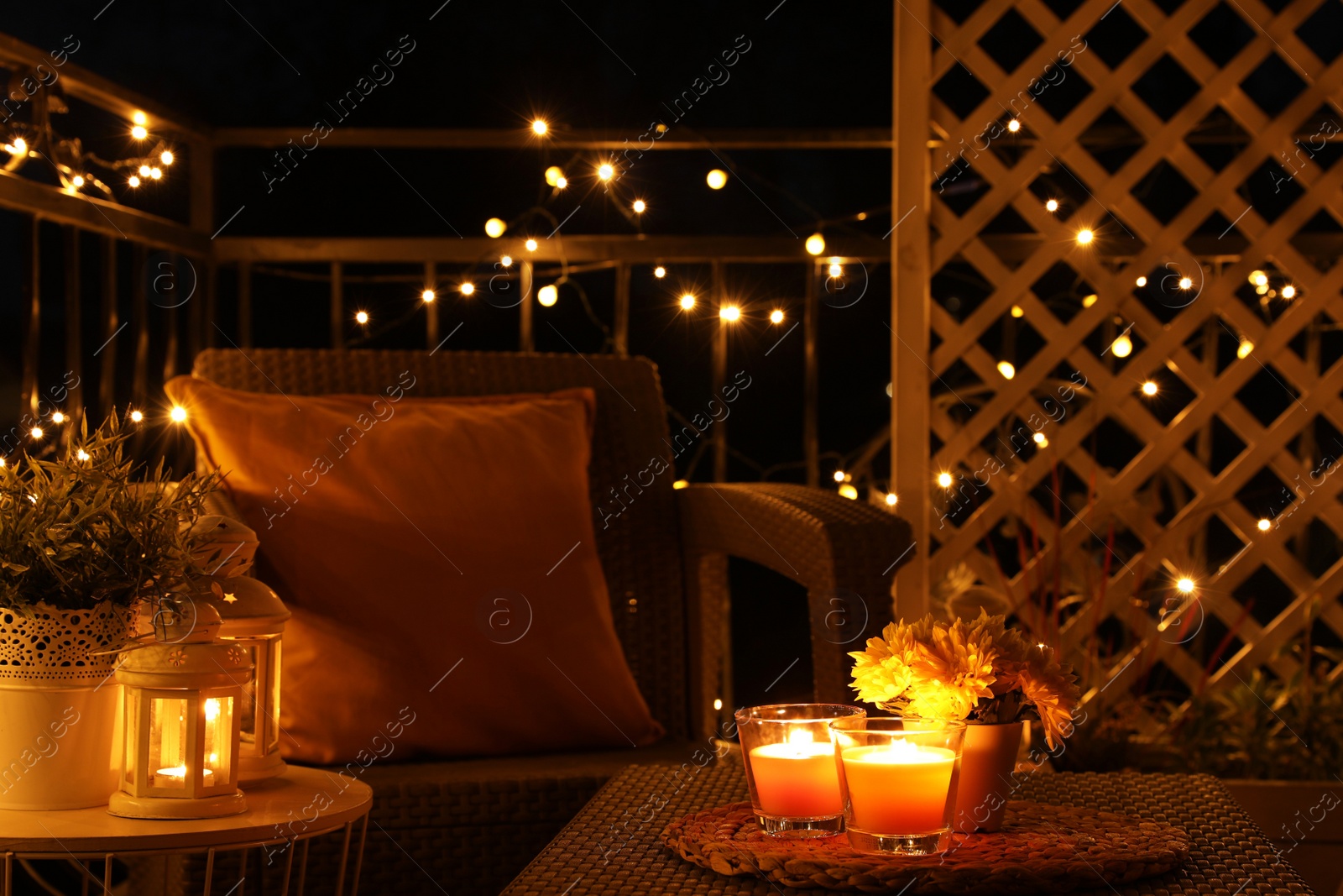 Photo of Beautiful view of garden furniture with pillow and burning candles at balcony