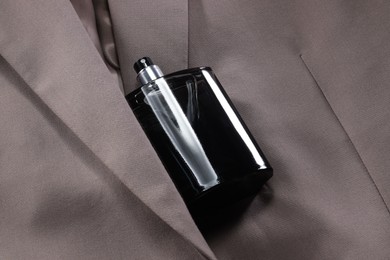 Photo of Luxury men's perfume in bottle on beige jacket