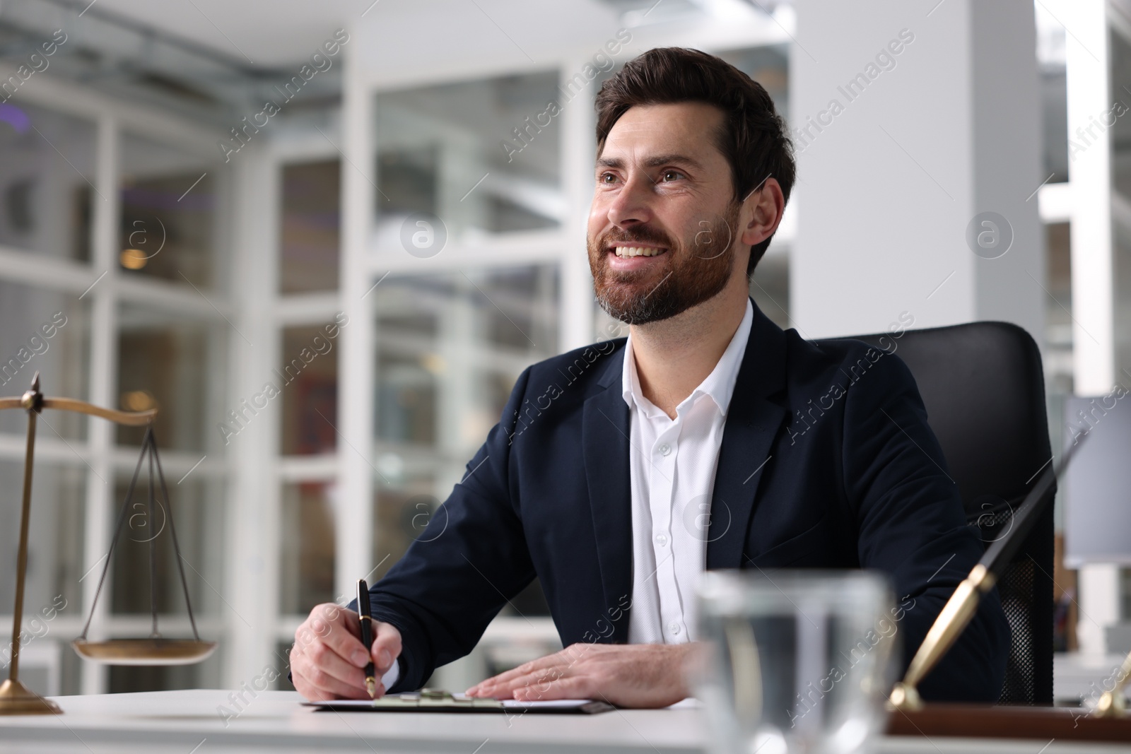 Photo of Portrait of smiling lawyer at table in office