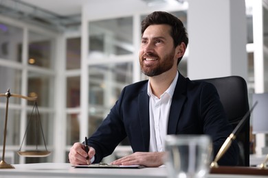 Photo of Portrait of smiling lawyer at table in office