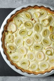 Photo of Freshly baked leek pie on grey textured table, top view