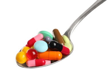 Photo of Spoon with different colorful pills on white background