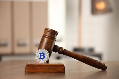 Photo of Law concept. Gavel and bitcoin on wooden table