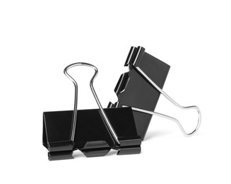 Photo of Black binder clips on white background. Stationery