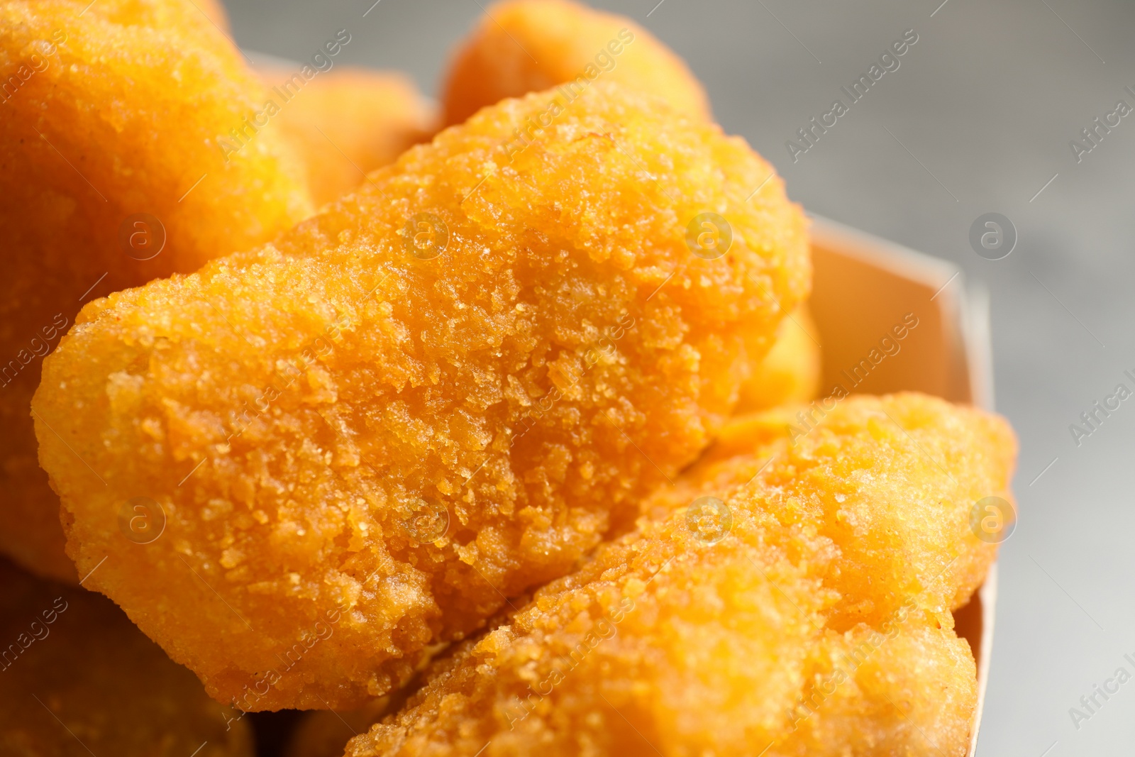 Photo of Tasty fried chicken nuggets on light background, closeup