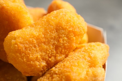 Tasty fried chicken nuggets on light background, closeup