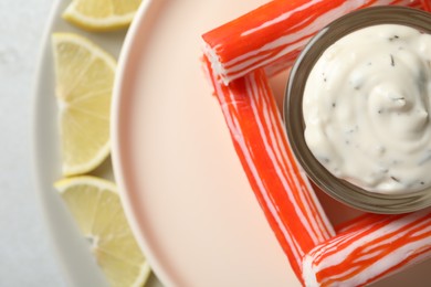 Crab sticks with sauce and lemon slices, closeup