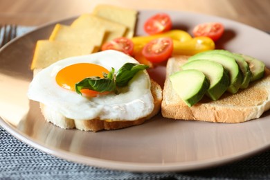 Photo of Tasty toasts with fried egg, avocado, cheese and vegetables on table, closeup