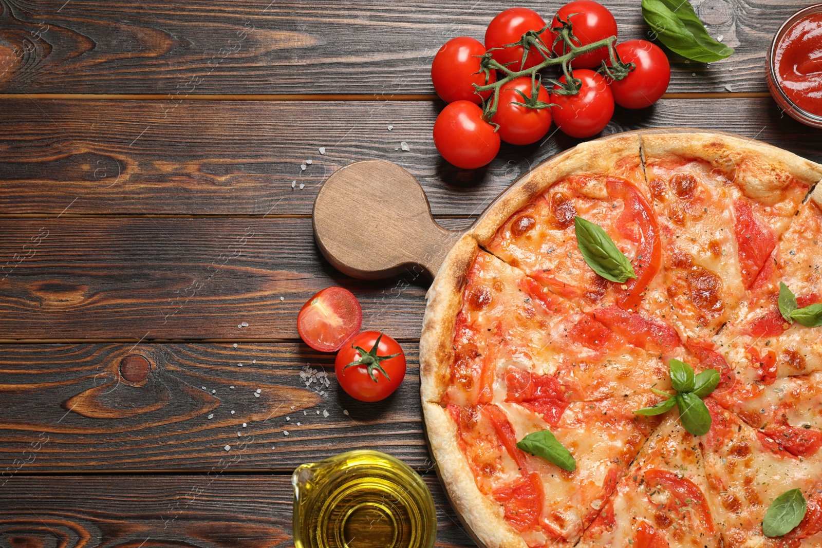 Photo of Delicious pizza Margherita and ingredients on wooden table, flat lay. Space for text