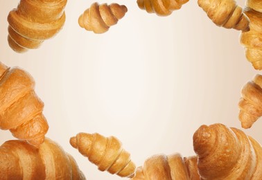 Image of Golden croissants falling on beige gradient background