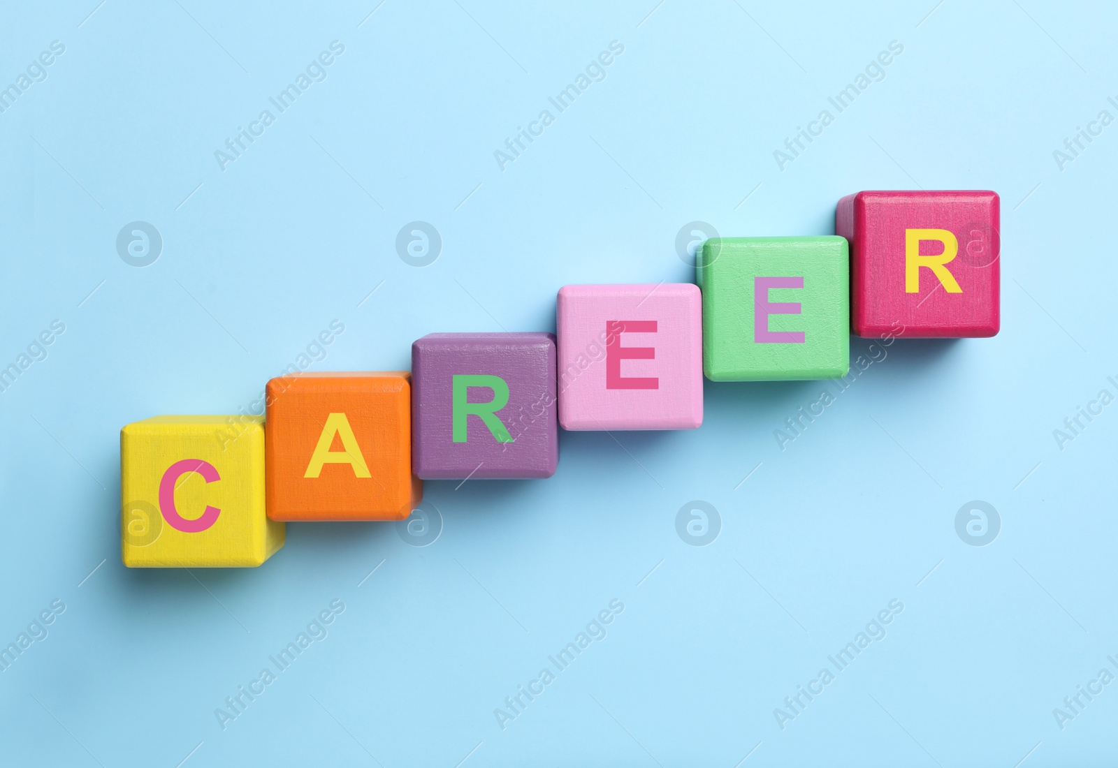 Photo of Colorful cubes with word CAREER on light blue background, flat lay