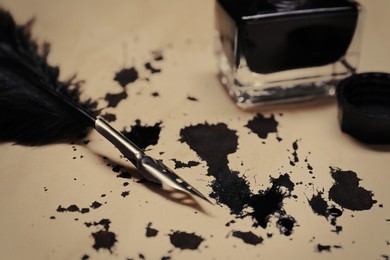 Photo of Feather pen and inkwell on vintage parchment with ink stains, closeup