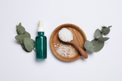 Aromatherapy products. Bottle of essential oil, sea salt and eucalyptus leaves on white background, flat lay