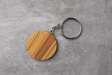 Photo of Wooden keychain in shape of smiley face on grey background, top view