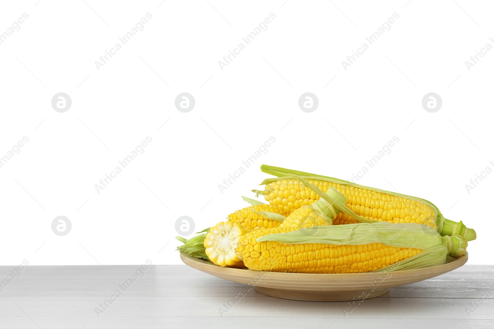 Photo of Tasty corn cobs on wooden table against white background