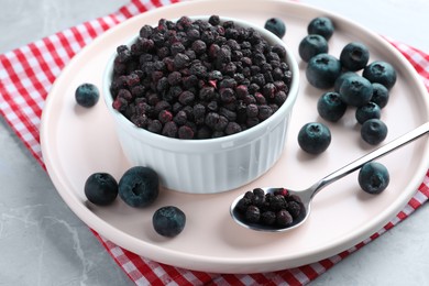 Photo of Freeze dried and fresh blueberries on light grey table, closeup