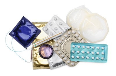Contraceptive pills, condoms, intrauterine device and thermometer isolated on white, top view. Different birth control methods