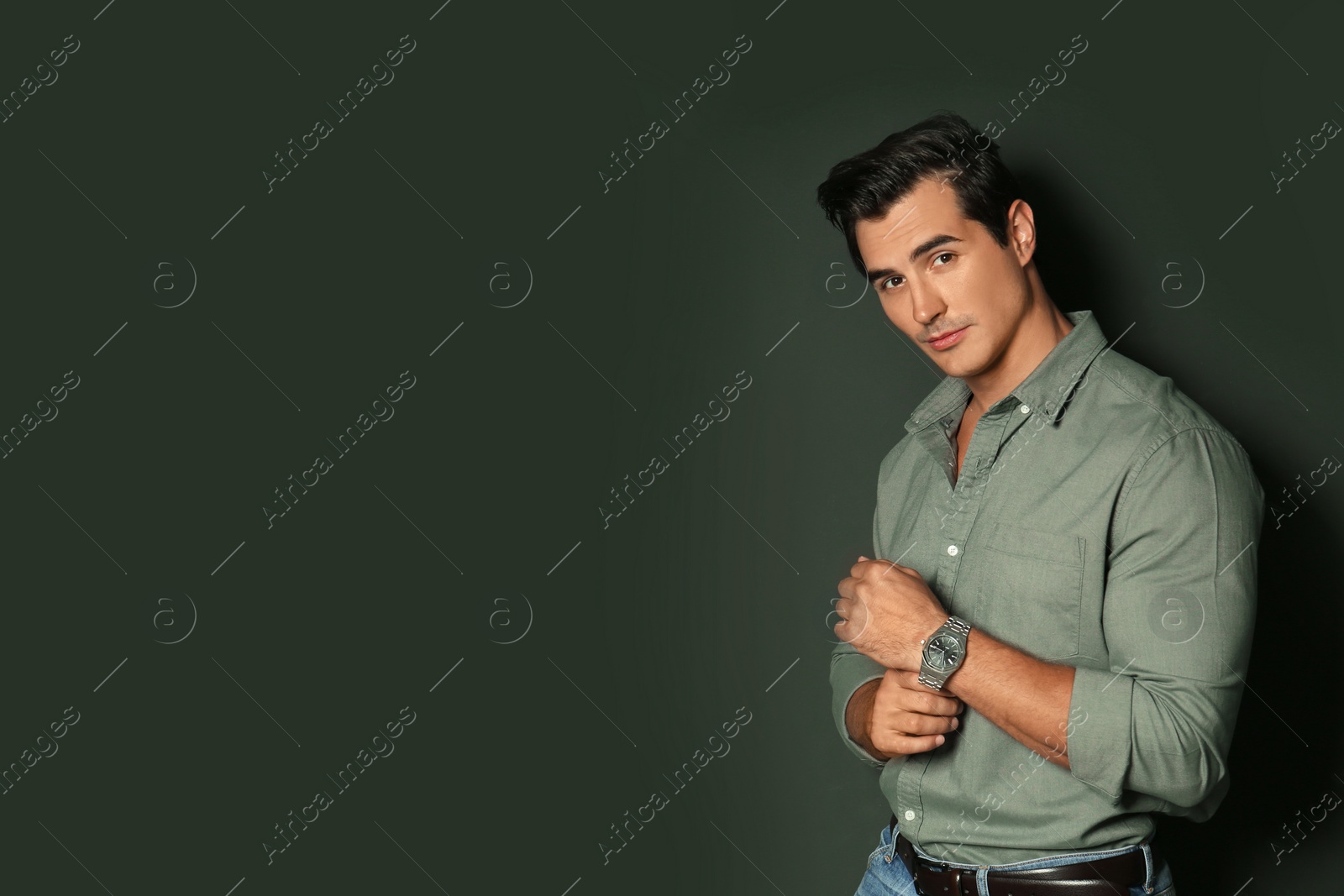 Photo of Handsome young man in stylish clothes on dark background. Space for text