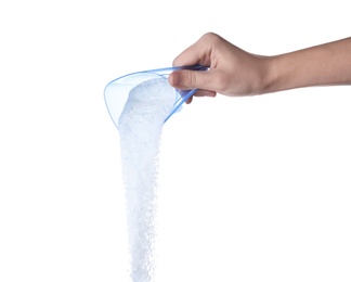 Photo of Woman pouring laundry detergent from measuring container against white background, closeup