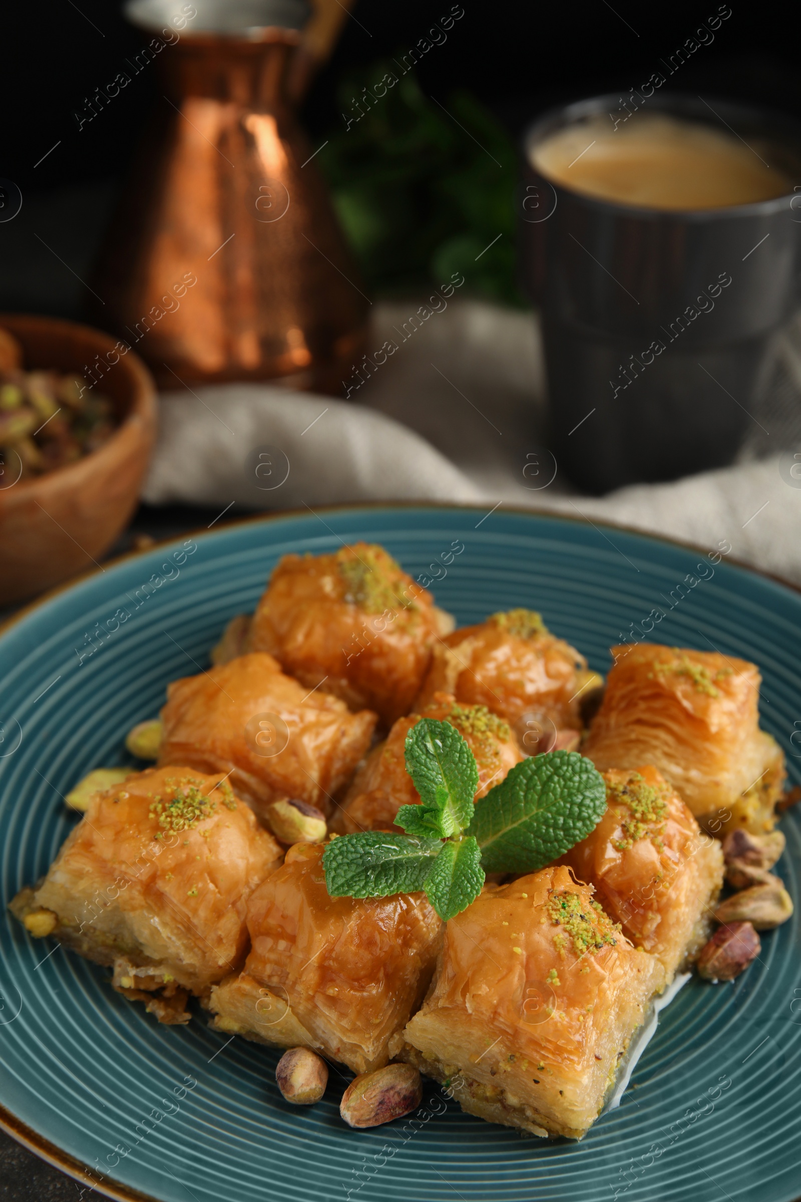 Photo of Delicious baklava with pistachio nuts and mint on plate, closeup