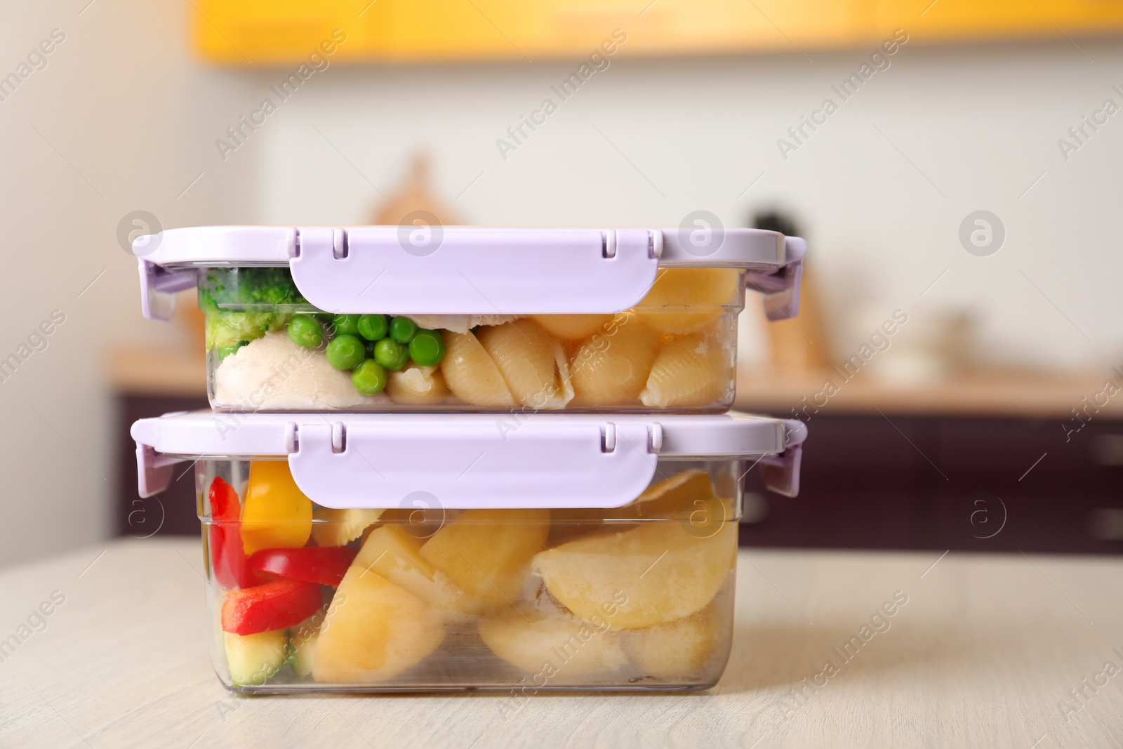 Photo of Boxes with prepared meals on table against blurred background