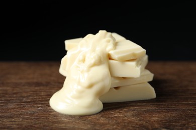 Photo of Pieces of white chocolate with tasty paste on wooden table, closeup