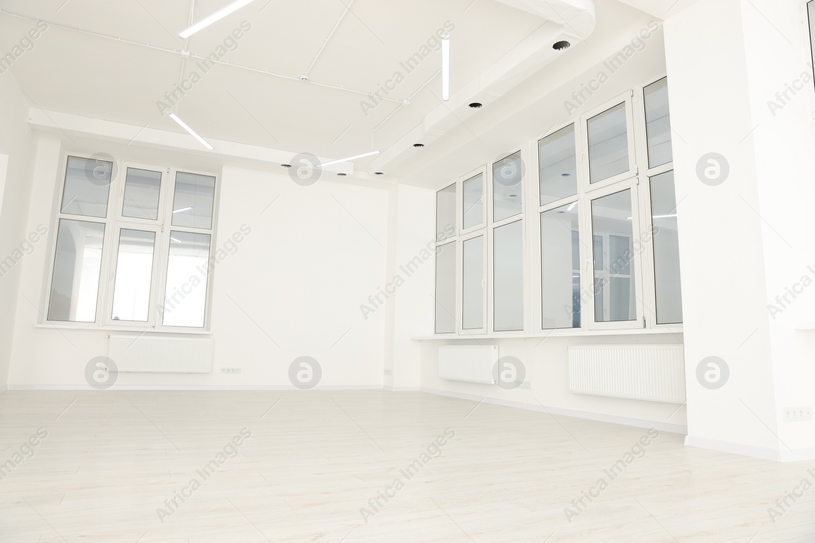 Photo of Modern office room with white walls and windows. Interior design