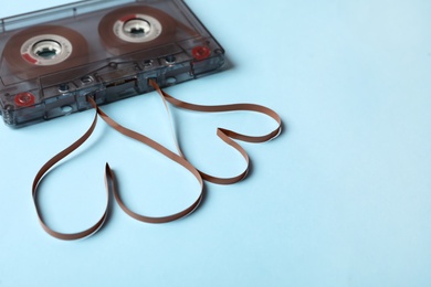 Photo of Music cassette and hearts made with tape on light blue background. Listening love song