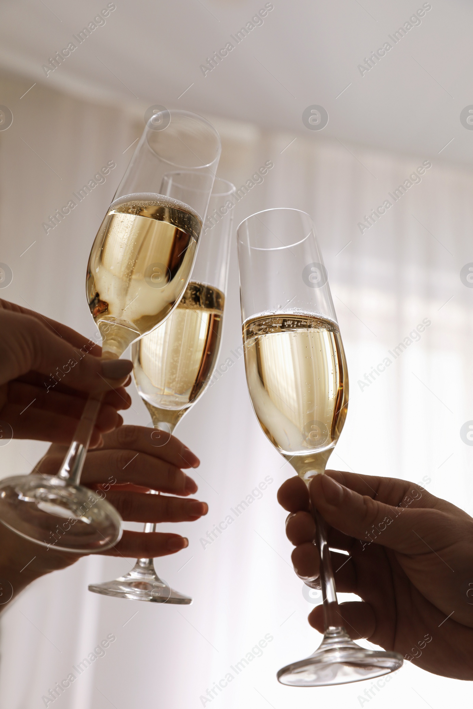 Photo of People clinking glasses with champagne at home, closeup