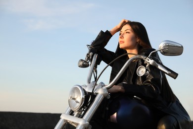 Photo of Beautiful young woman sitting on motorcycle outdoors