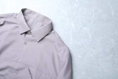 Photo of Stylish shirt on grey marble table, top view with space for text. Dry-cleaning service