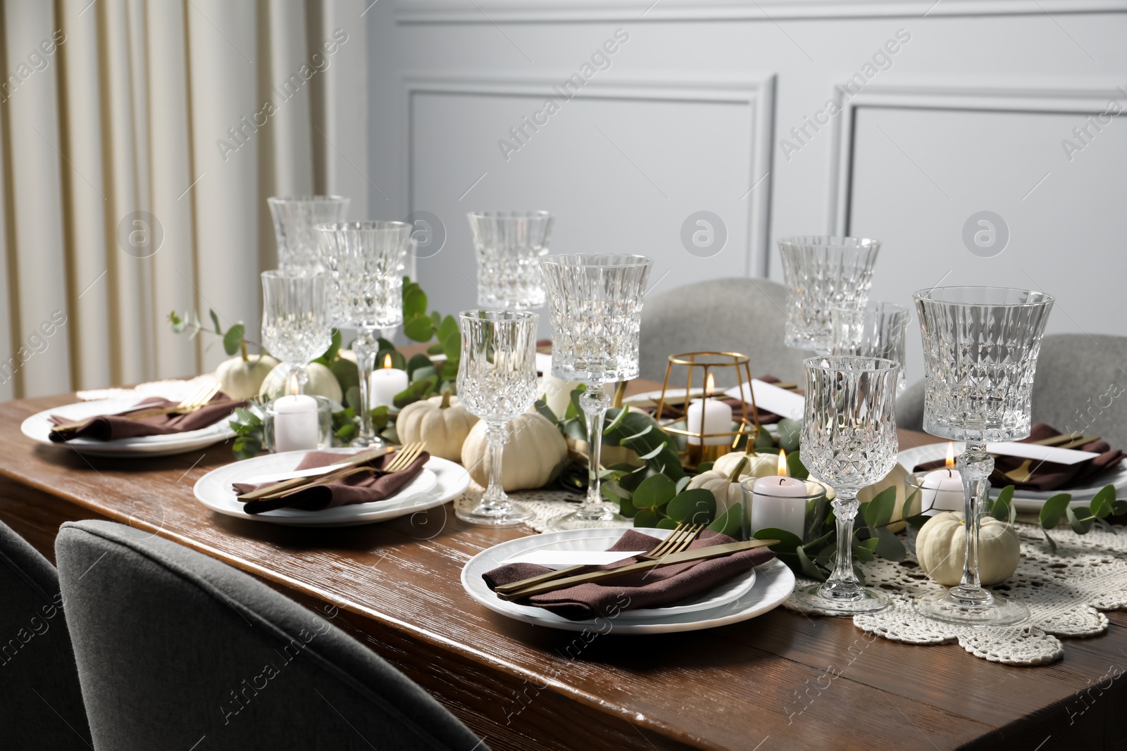 Photo of Beautiful autumn table setting. Plates, cutlery, glasses, blank cards and floral decor