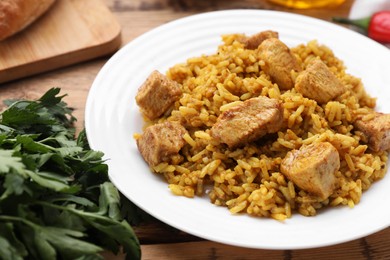 Delicious rice with chicken served on wooden table, closeup