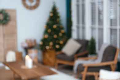Photo of Blurred view of decorated Christmas tree in living room interior