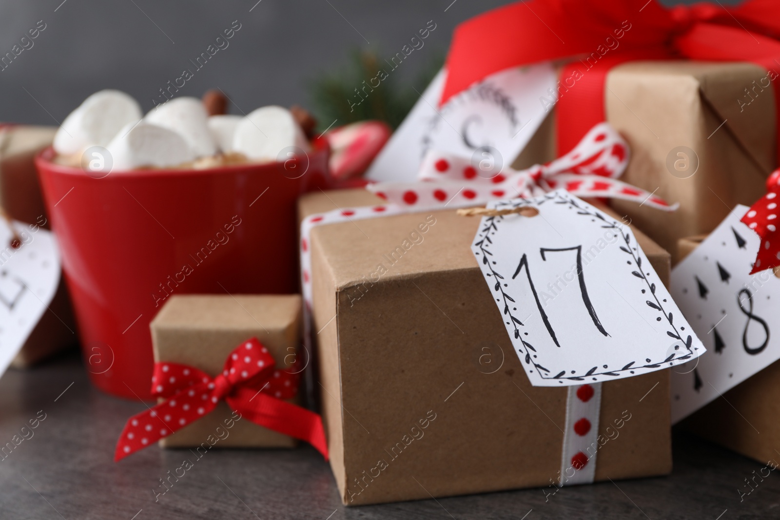 Photo of Christmas advent calendar with gifts on grey table, closeup