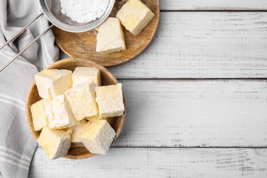 Tasty marshmallows and powder sugar on white wooden table, flat lay. Space for text