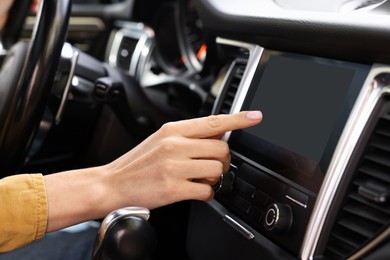 Photo of Woman using navigation system while driving her car, closeup