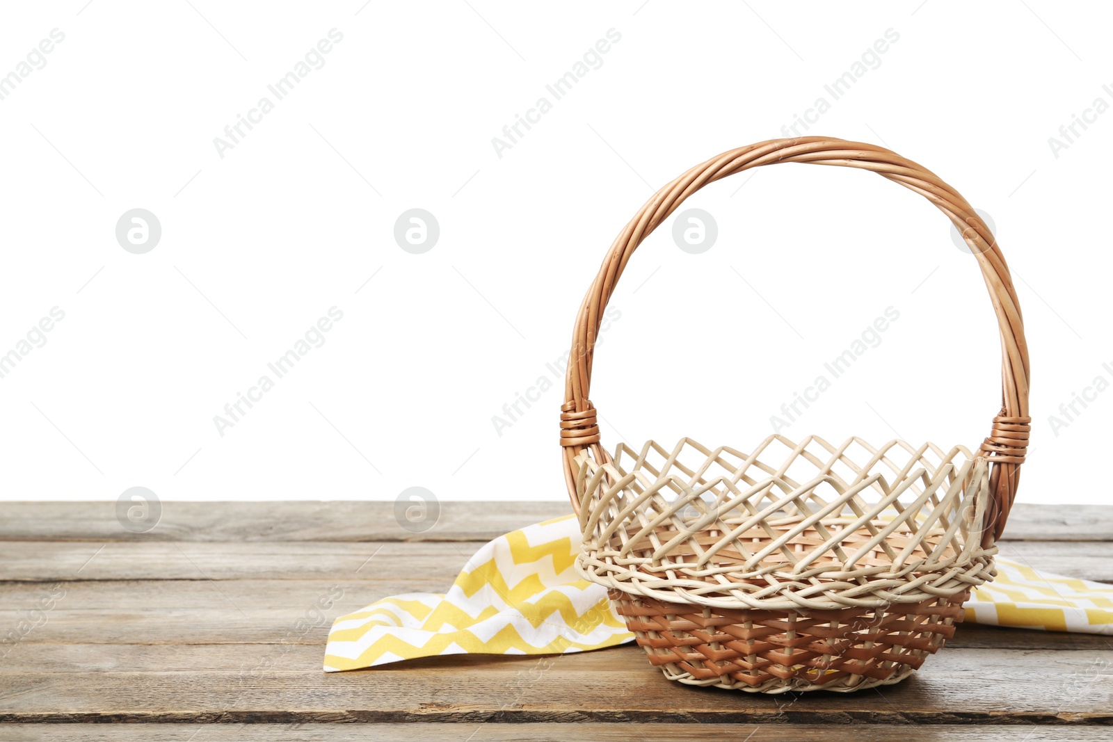 Photo of Empty wicker basket and cloth on wooden table against white background, space for text. Easter holiday