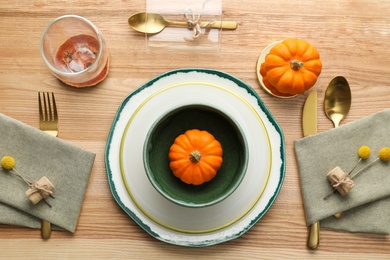 Photo of Autumn table setting with pumpkins on wooden background, flat lay