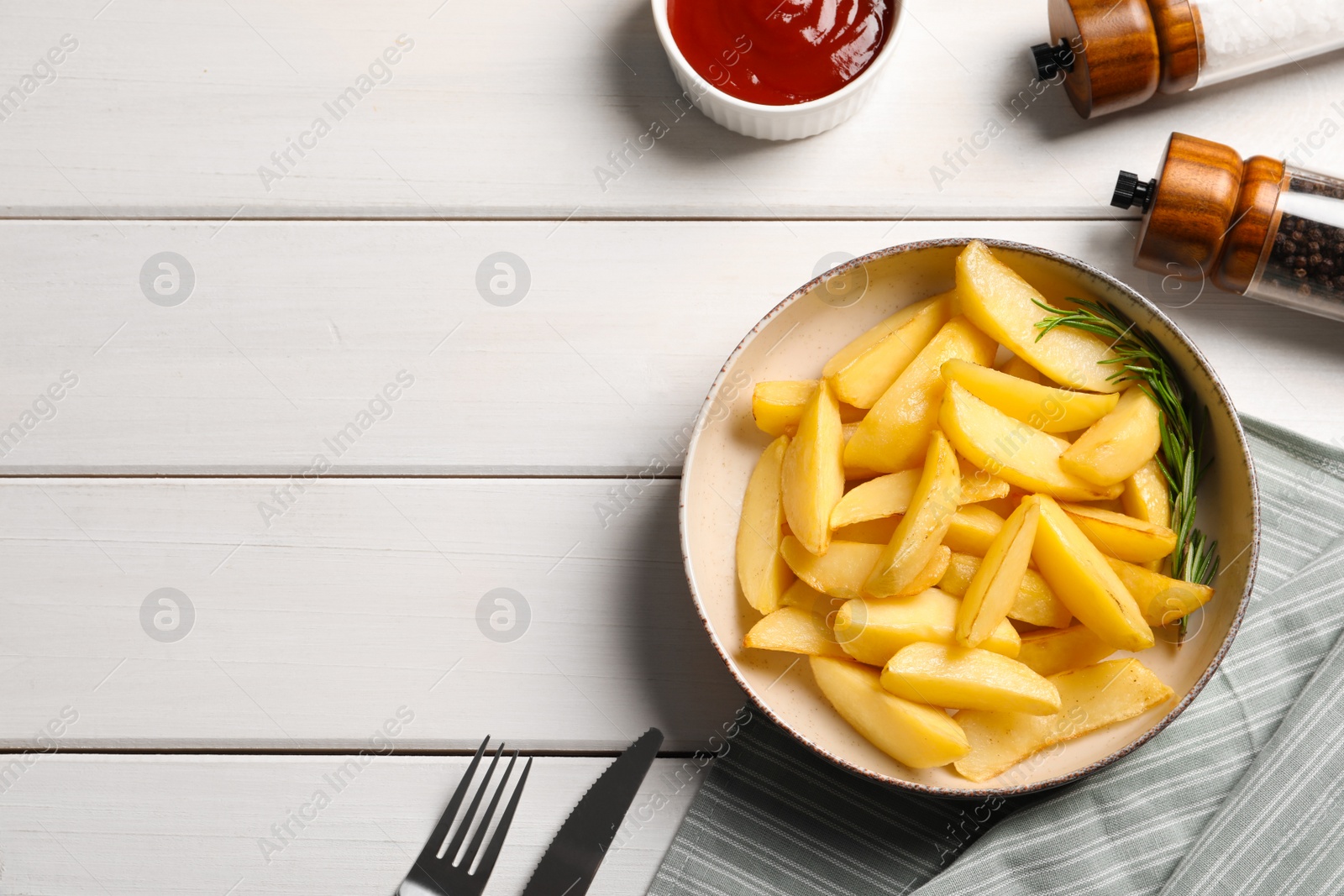 Photo of Plate with tasty baked potato wedges, rosemary and sauce on white wooden table, flat lay. Space for text