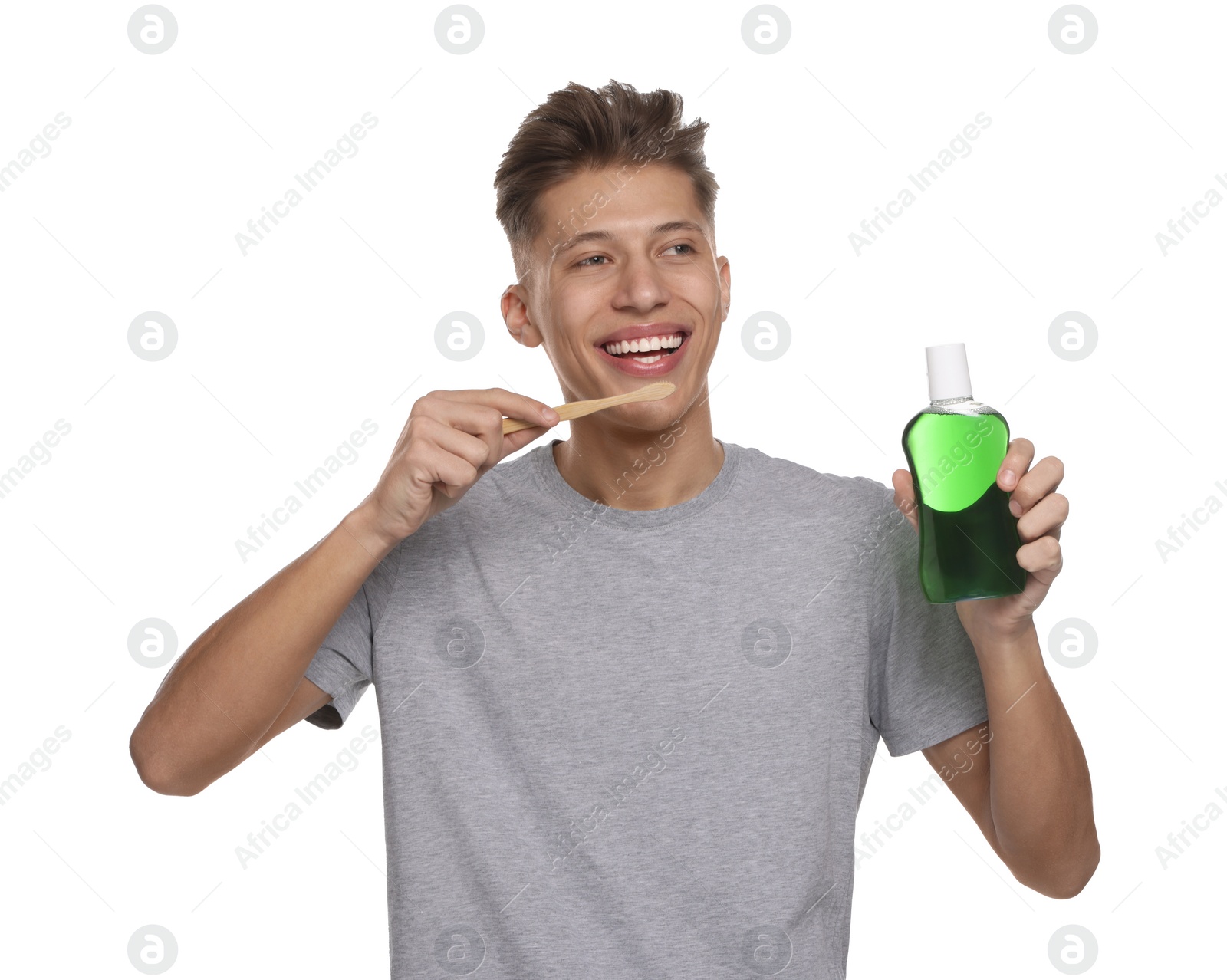 Photo of Young man with mouthwash and toothbrush on white background