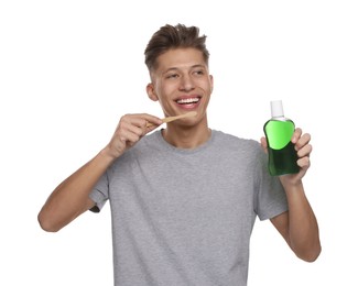 Photo of Young man with mouthwash and toothbrush on white background