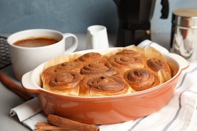 Photo of Baking dish with cinnamon rolls on table