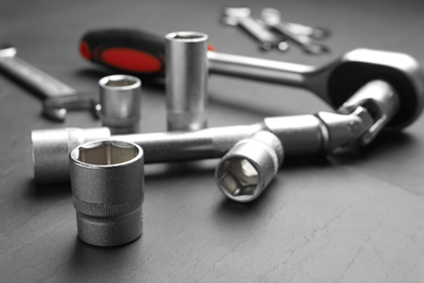 Photo of Auto mechanic's tools on grey background, closeup